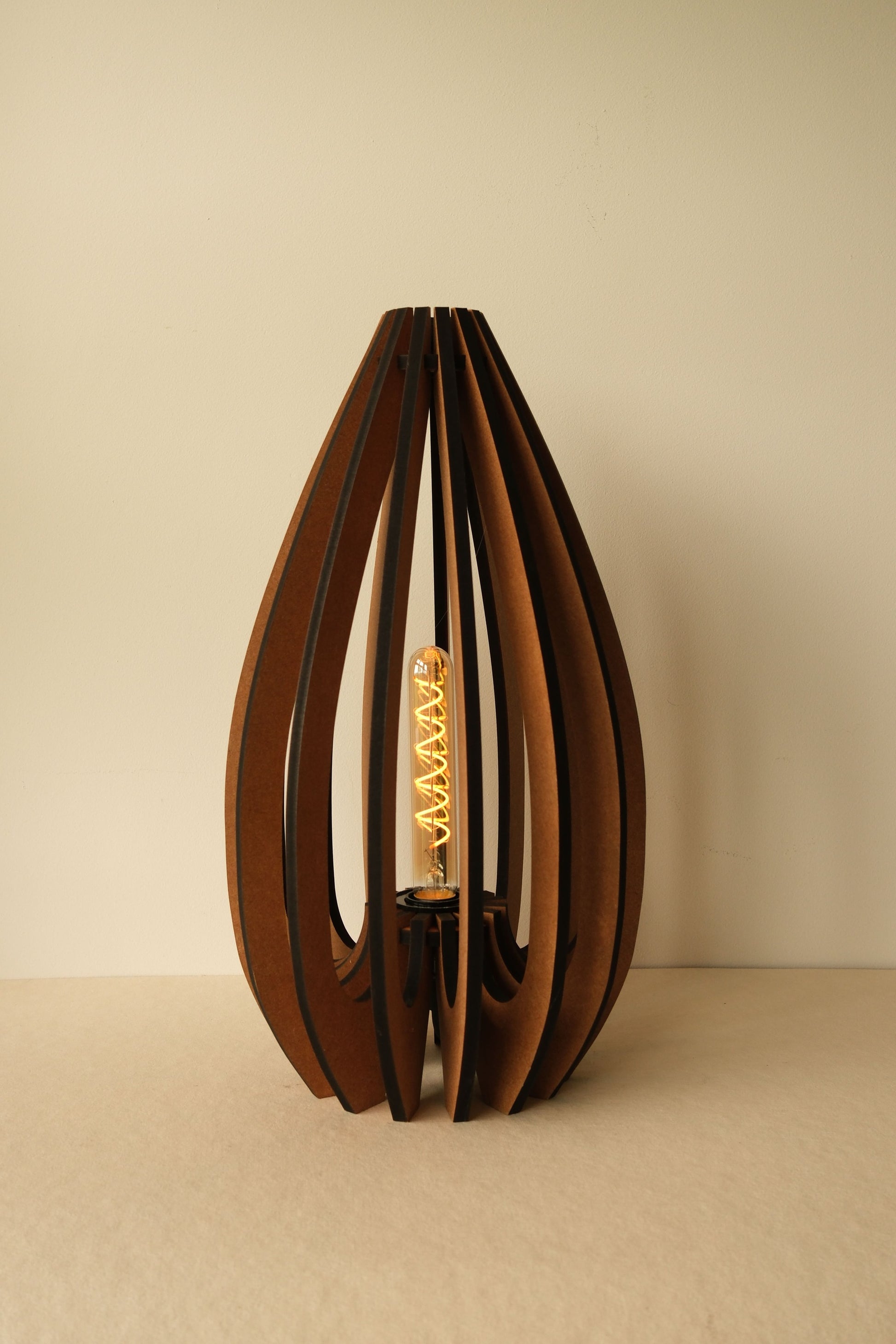 De grote Tulp houten design tafellamp in Walnoot met zwarte rand afwerking, 27×27×50 cm. Licht is gedimd