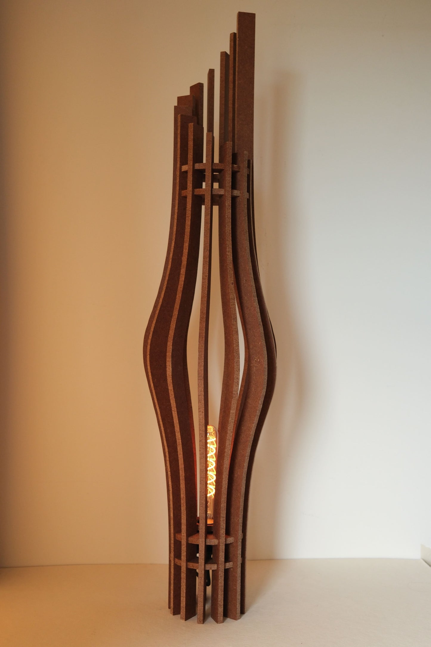 De Zaangolf design vloerlamp van 9 mm MDF in Amber afwerking, golvende vorm in warm licht