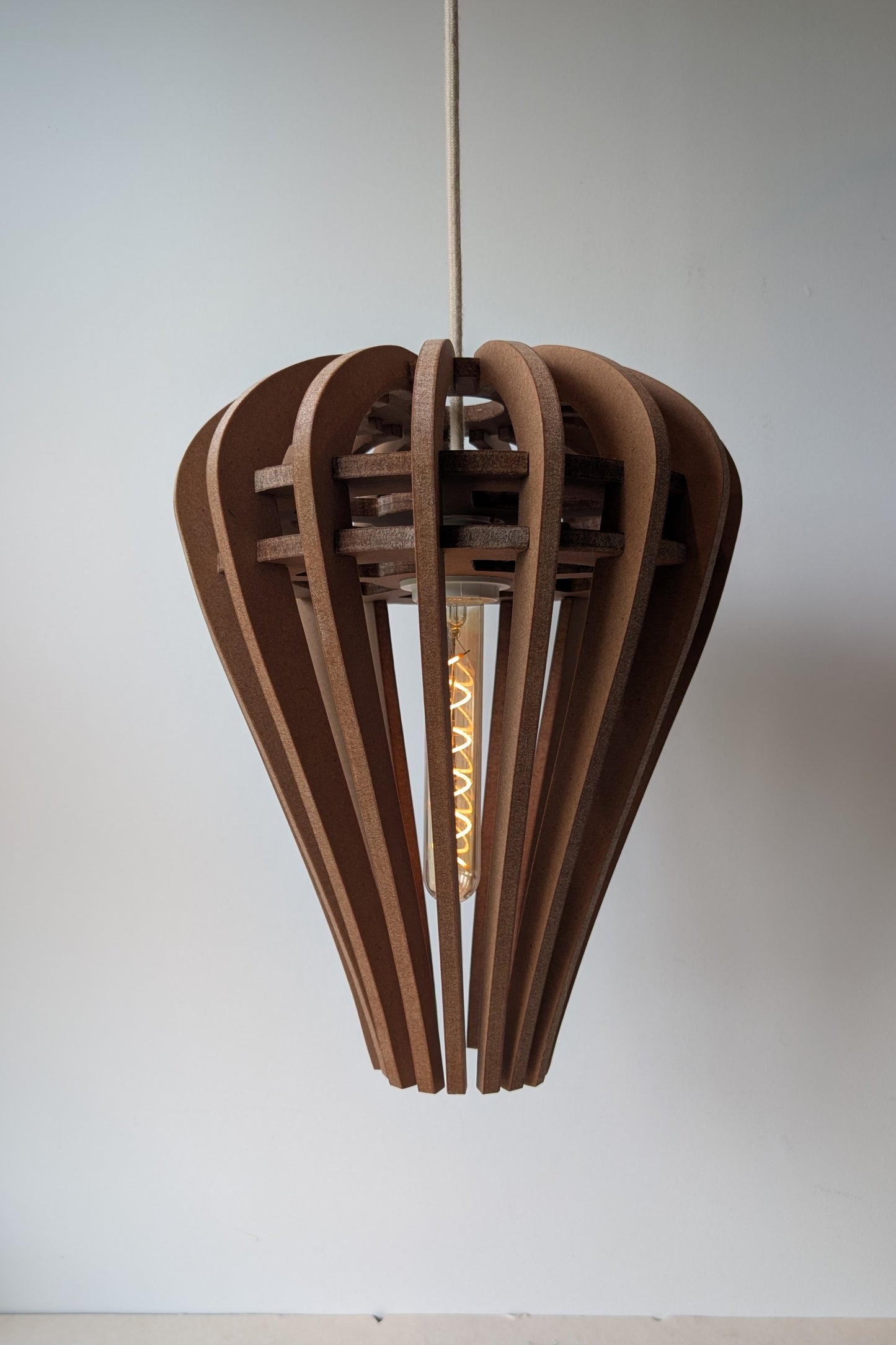 De Druppel houten design hanglamp in Amber afwerking, zachte druppelvorm, boven een eettafel