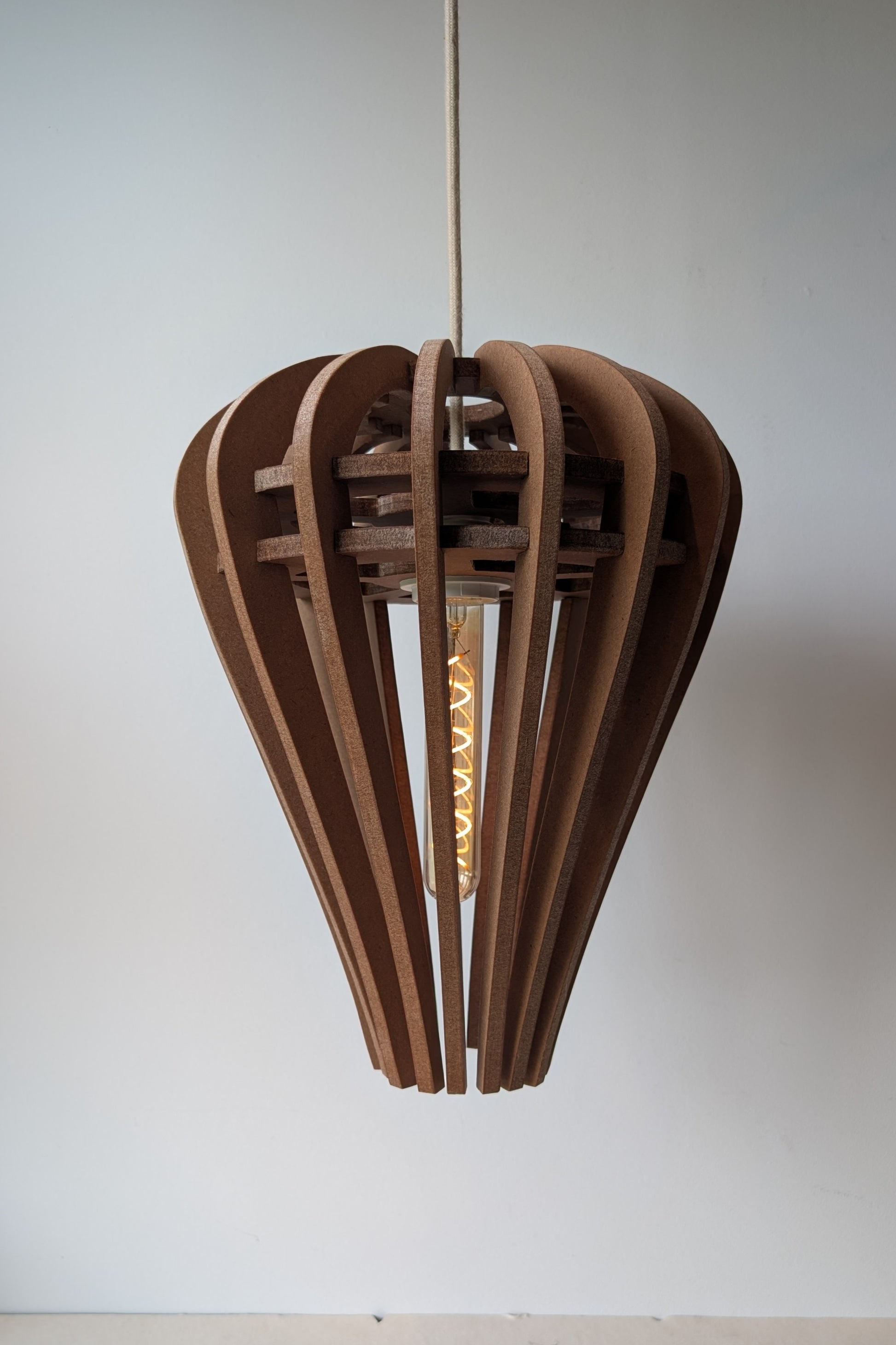 De Druppel houten design hanglamp in Amber afwerking, zachte druppelvorm, boven een eettafel