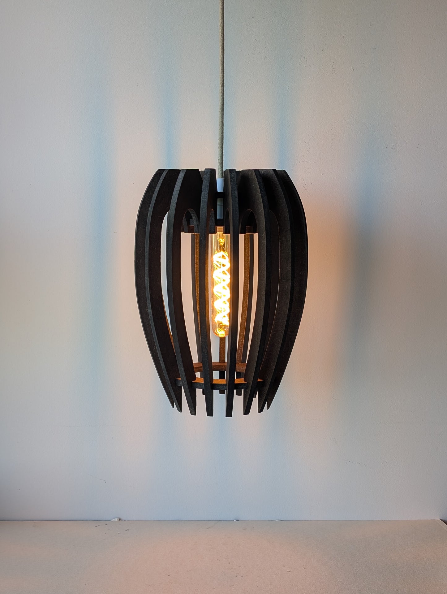 De Mantel design hanglamp in Walnoot afwerking met dimbare lamp aan, warme sfeerverlichting